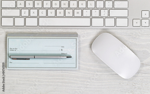 Photography Blank checkbook on white desktop with pen and mouse