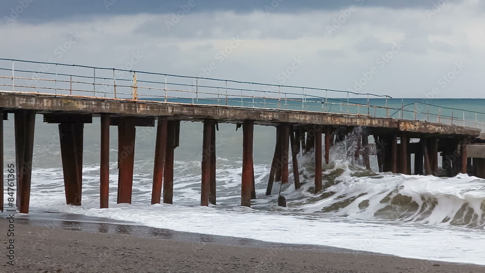 Stormy seaside in winter, abandoned pier in stormy sea 
