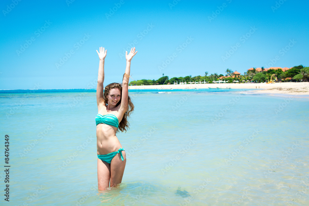 Young woman smiling at camera in front of sea shore Young woman smiling at camera in front of sea shore