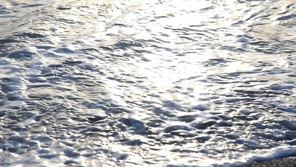 Waves on beach in sunlight, closeup Waves on beach in sunlight, closeup