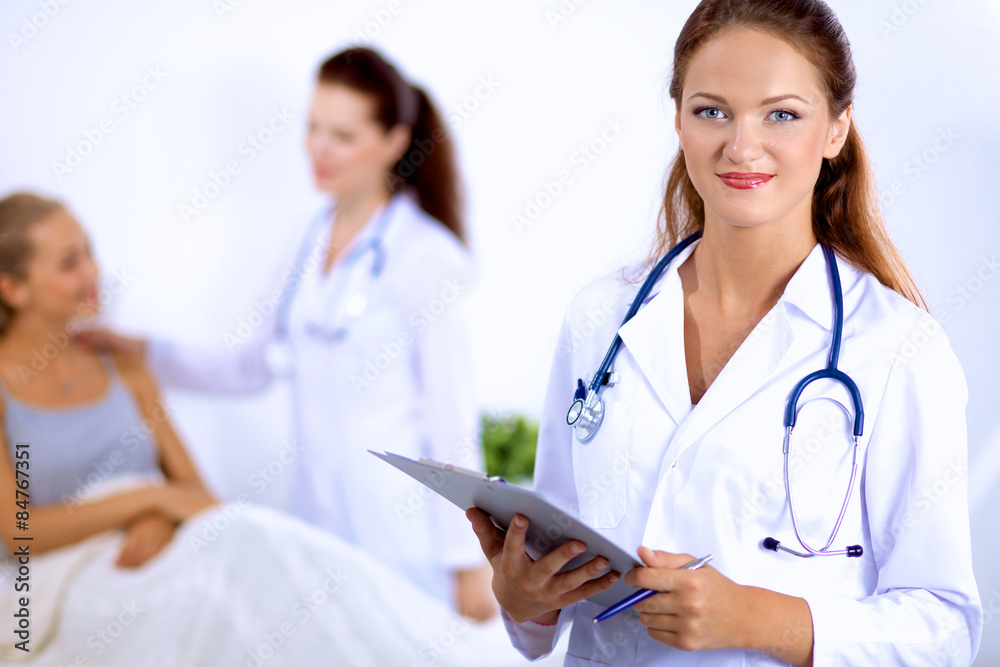 Smiling female doctor with a folder in uniform standing at Smiling female doctor with a folder in uniform standing at