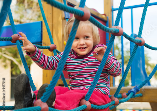 Photos Happy little girl at action-oriented playground
