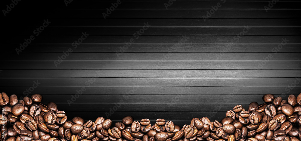 Coffee cup and coffee beans on a black wooden table. Dark background 