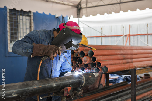 Worker welding the steel part by manual