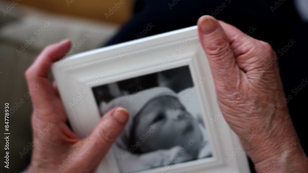 Grandmother holds framed photo of baby 