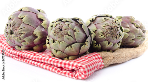 Fresh green purple artichokes on burlap