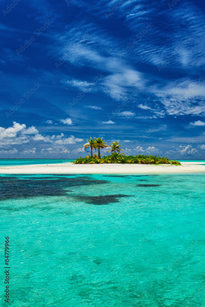 Small island surrounder by reef and beach in Maldives