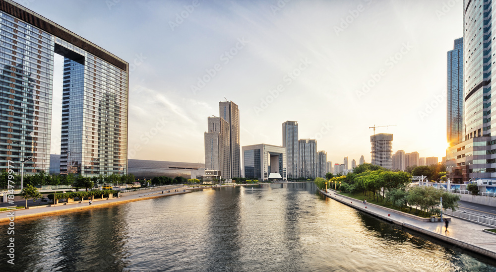 modern skyscrapers and skyline during sunset at riverbank