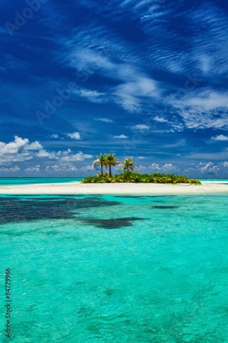 Small island surrounder by reef and beach in Maldives