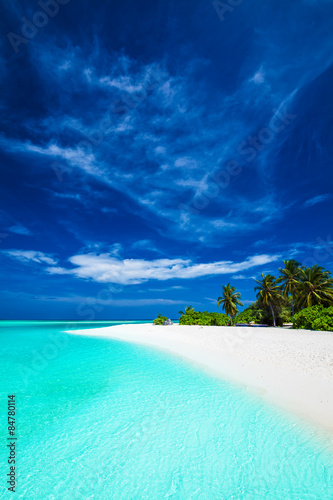White tropical beach with beautiful sky with palm trees and blue