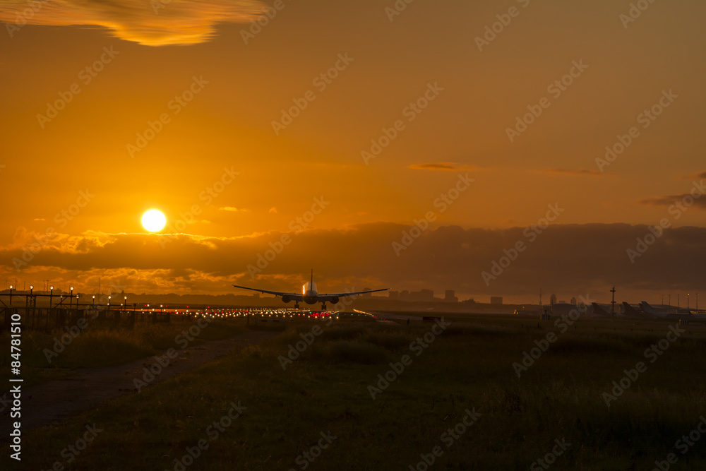 Airplane safely landed during a nice cloudy sunrise.