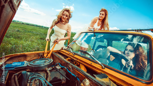 Beautiful women with tools are repairing a car on the rural road © diter