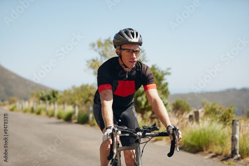Young man riding bicycle on open road