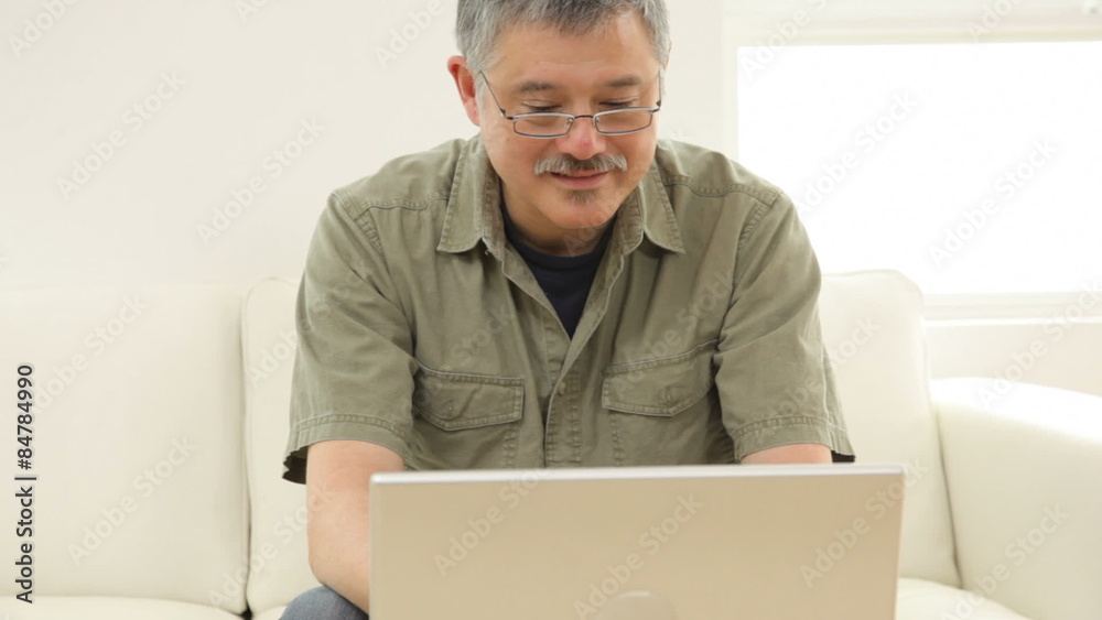 Mature Asian man with laptop computer & coffee Mature Asian man with laptop computer & coffee