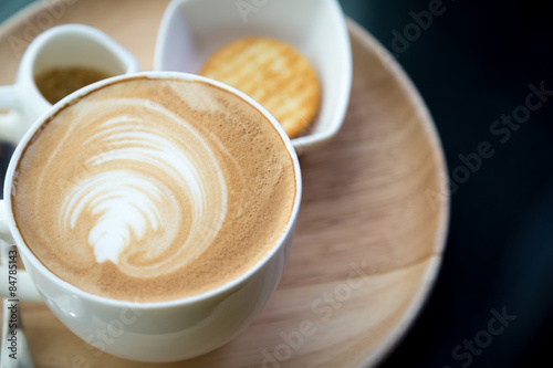 Hot latte art coffee on table