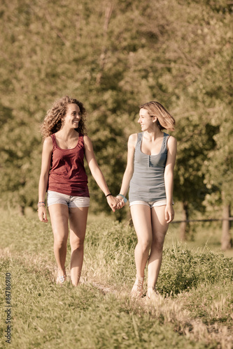 Two Beautiful Teenage Girls Walking at Park