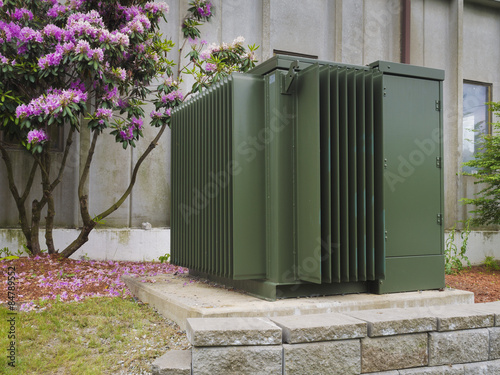 Industrial power transformer on the side of an commercial building