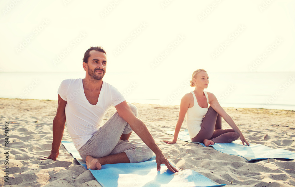 Fototapeta premium couple making yoga exercises outdoors