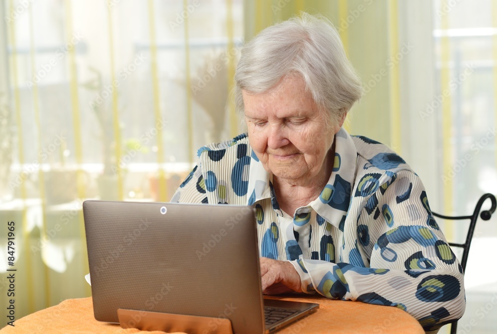 Senior woman with laptop in her room.