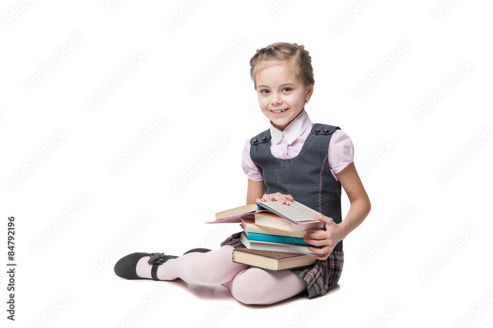 Beautiful little girl in school uniform with books sitting on Beautiful little girl in school uniform with books sitting on