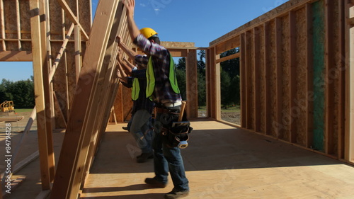Group of construction workers staning up wall