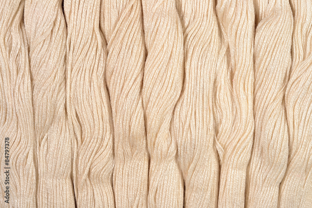 Beige skeins of floss as background texture