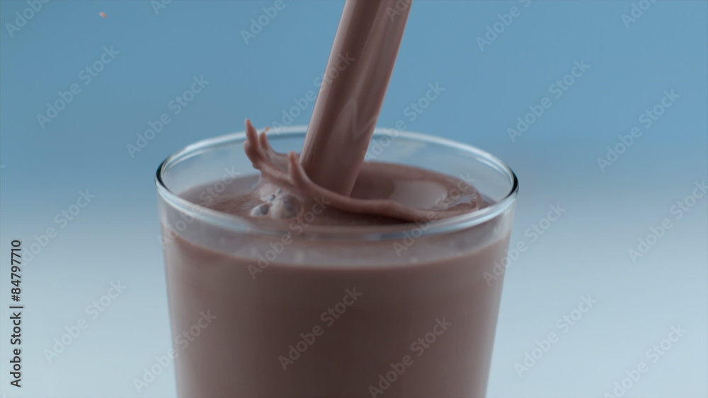 Chocolate milk pouring and splashing in slow motion