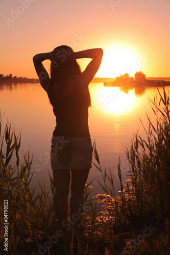 Girl at the lake at sunset