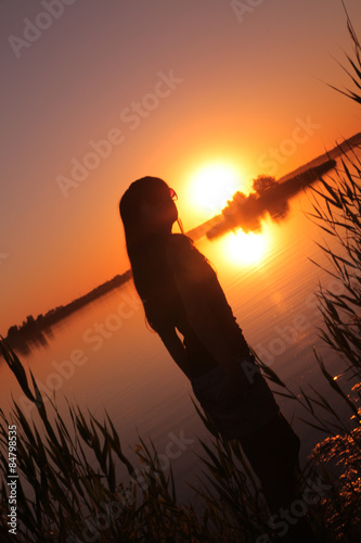 Girl at the lake at sunset