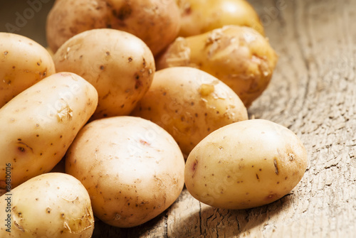 Fresh potatoes in an old wooden table  selective focus