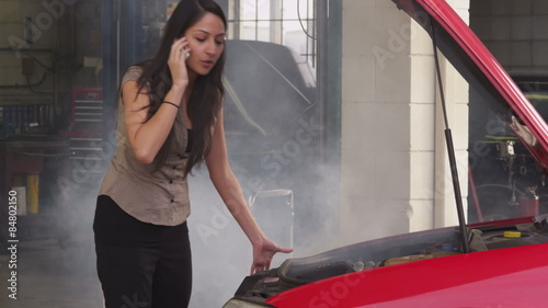 Woman having car trouble and talking on cell phone