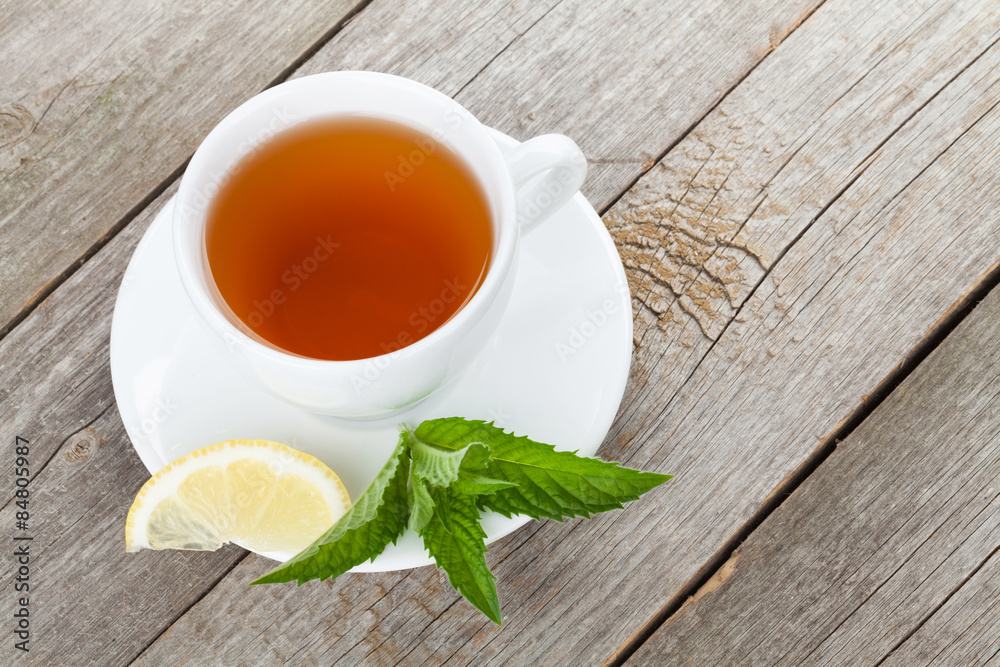Green tea with lemon and mint on wooden table
