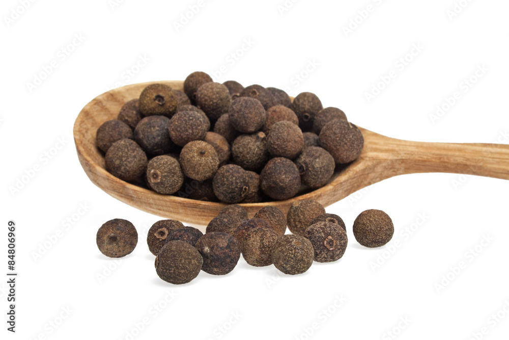 Grains of allspice on wooden spoon isolated on white background Grains of allspice on wooden spoon isolated on white background
