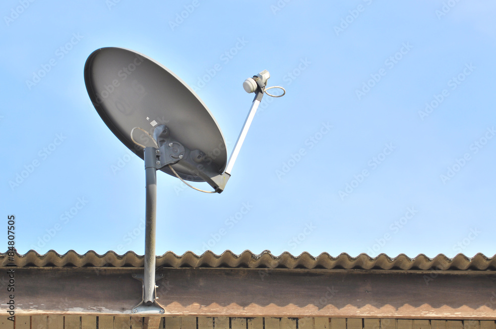 Satellite dish with blue sky on roof.