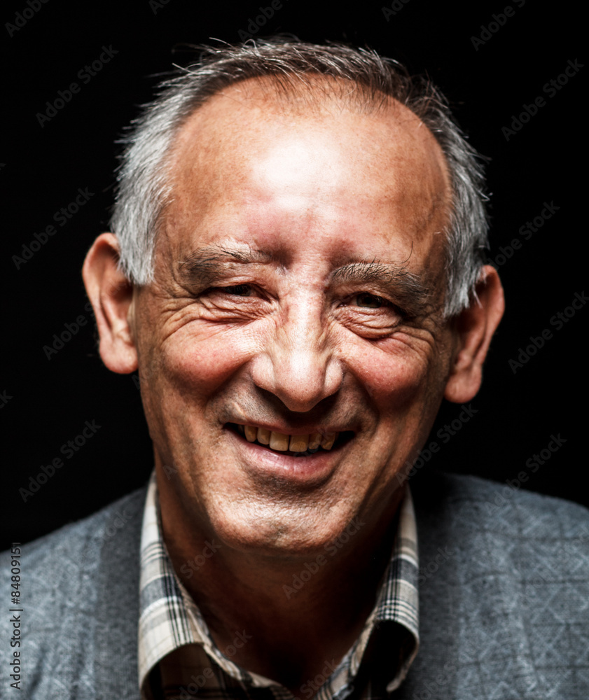Obraz premium Portrait of smiling senior man on black background, Front view.