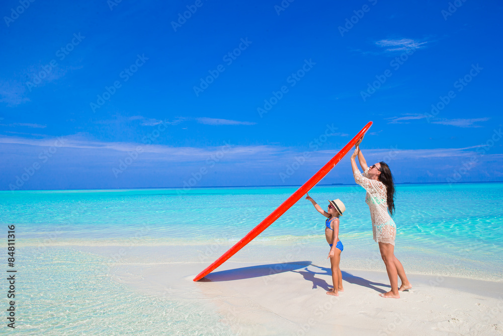 Happy woman and little girl at white beach with surfboard Happy woman and little girl at white beach with surfboard