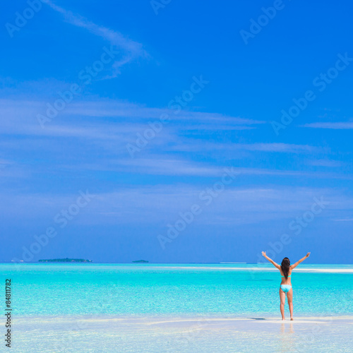 Young happy woman on white sandy beach