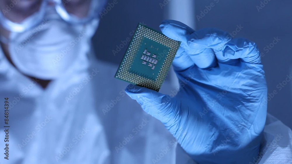 Man in clean room holds up computer cpu microchip