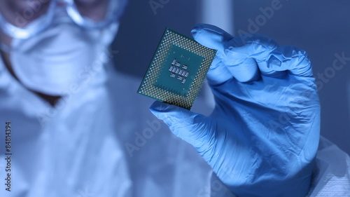 Man in clean room holds up computer cpu microchip photo