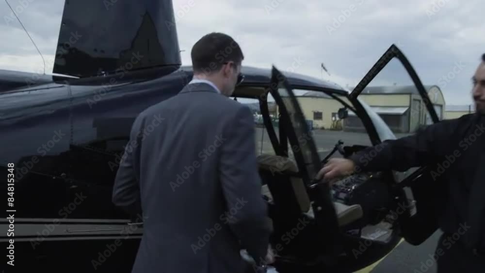 Businessman getting into helicopter