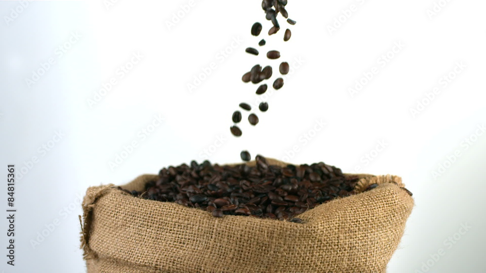 Coffee beans fall into burlap sack, slow motion Coffee beans fall into burlap sack, slow motion