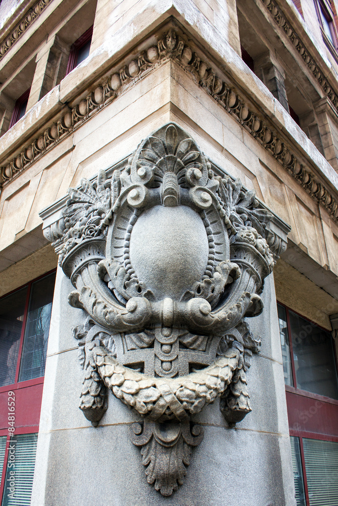 Limestone Crest - Ornate Gray Limestone Crest Mounted on Brown Stone Building Corner