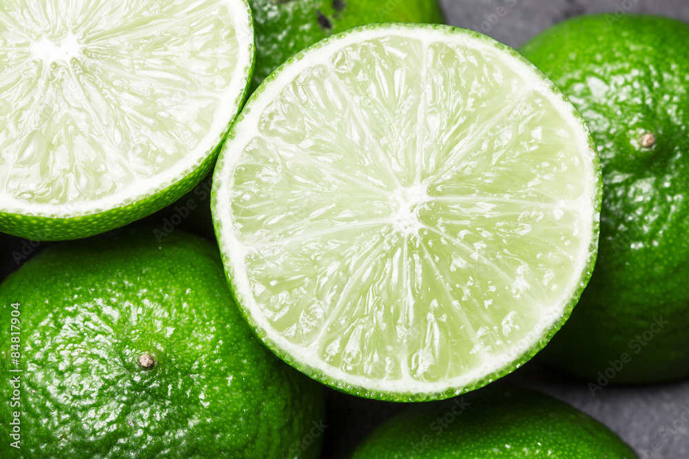 Fresh limes cut in half on black surface Fresh limes cut in half on black surface