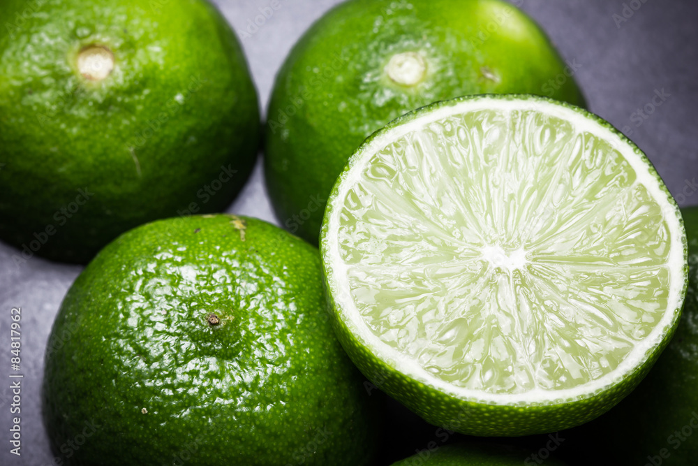 Fresh limes cut in half on black surface Fresh limes cut in half on black surface