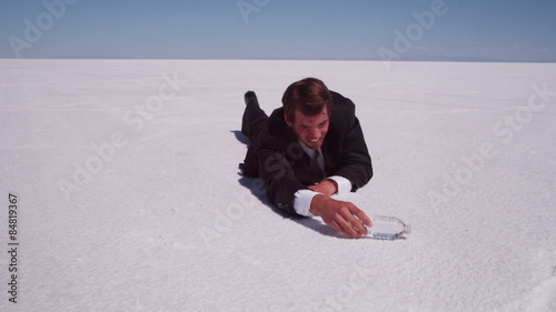 Thirsty businessman crawling for water