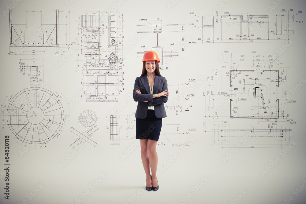 woman in hardhat over grey wall with prints woman in hardhat over grey wall with prints