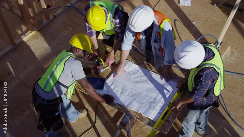 Overhead shot of construction workers lookin at plans