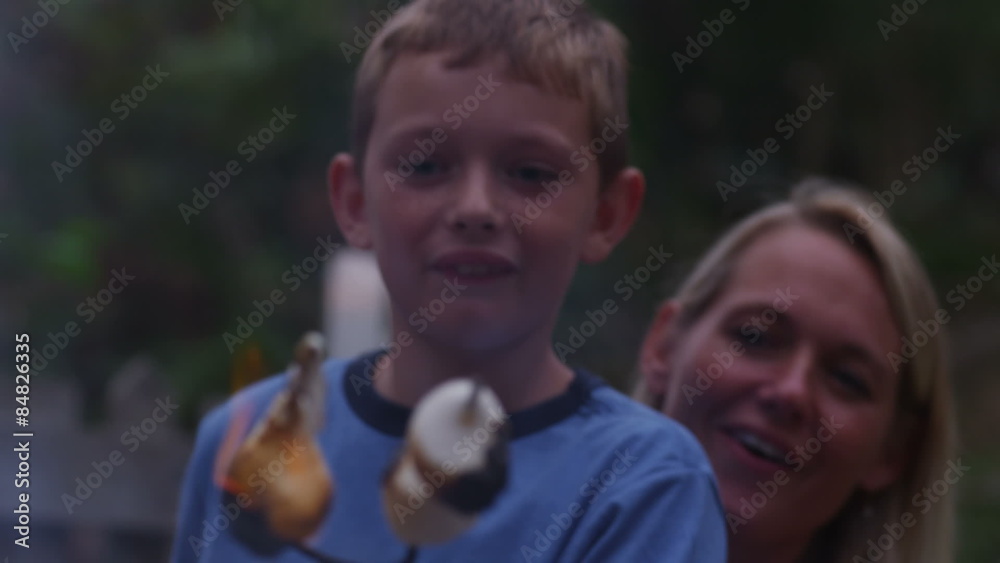 Mother and son roasting marshmallows by outdoor fire. Mother and son roasting marshmallows by outdoor fire.