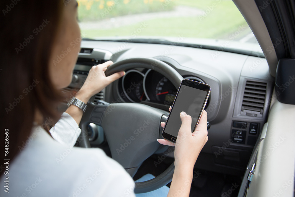 Woman using cellphone inside a car, taken from behind