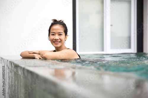 Happy beautiful asian woman enjoying time on the pool